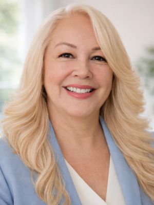 A woman with long blonde hair wearing a red and blue shirt.